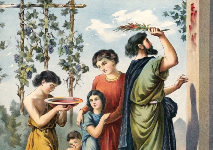 man applying blood to doorpost with family around